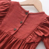 Generic Firebrick Ruffled Long Sleeve Romper Bodysuit, close-up of the red fabric with button details and ruffled sleeves.
