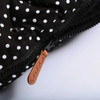 Minnie Me Stroller Bag Winter Windproof Sleeping Bag, close-up of black fabric with white polka dots and a brown zipper pull with the brand name engraved.