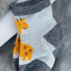 Generic Giraffe Layette Set 4 Piece, knitted baby sock featuring yellow giraffe design on white and gray background.