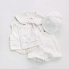 OONA John White Suit, baby boy formal outfit with a vest, shorts, a hat, and a cape with a bow, all in white fabric.