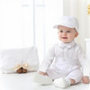 Minnie Me Liam Suspender Set, baby boy dressed in white suspender outfit with matching cap sitting indoors for a photo