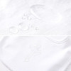Minnie Me Cotton Romper Neutral, close-up of the white cotton romper showing water droplets and a subtle embroidered cross detail.