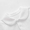 Minnie Me White Cotton Ribbed Romper, close-up of the textured white fabric and Peter Pan collar with snap buttons.