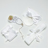 Minnie Me White 5 PCS Baptism Kit, a collection of white baptism accessories including a rosary, lace-trimmed cloth, favor boxes with bows, and a shell-shaped holder for religious items.
