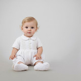 Minnie Me Mike White Baptism Romper, adorable baby girl sitting in white baptism romper with lace details and white socks.