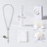 Minnie Me Catholic Baptism Candle Set, arranged with a white candle wrapped in lace with a cross pendant, a white prayer booklet with lace, a rosary with a cross pendant, and white shells with satin bows for a baptism ceremony.