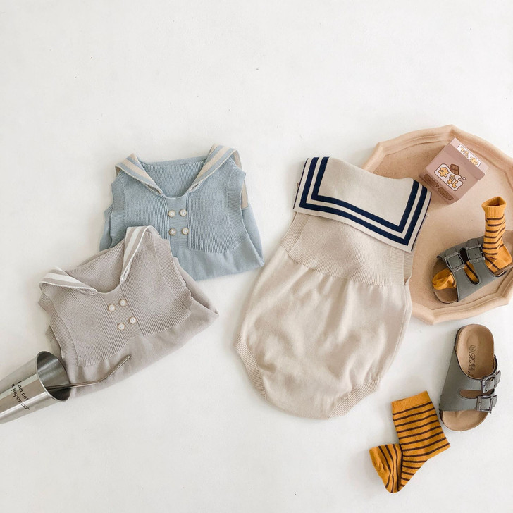 Engepapa Sand Dollar Beige Knitted Navy Collar Romper, beige knitted romper with navy collar and sailor shirt design, displayed on a flat surface with accessories.