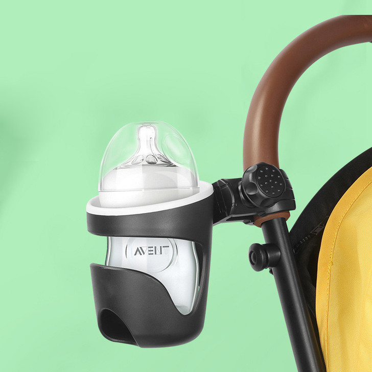 Joyren Black Universal Cup Holder For Strollers And More, black cup holder attached to stroller handle with baby bottle inside, suitable for organizing drinks and bottles.