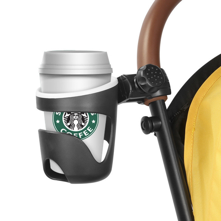 Joyren Black Universal Cup Holder For Strollers And More, black cup holder attached to stroller handle with a white coffee cup featuring Starbucks logo.