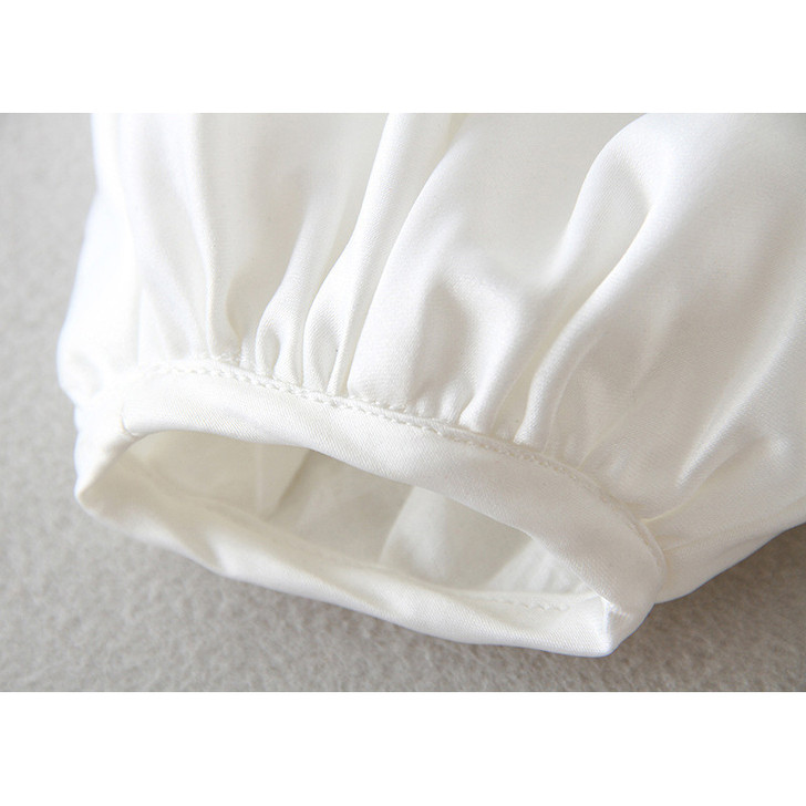 OONA 2 PCS Baptism White Satin Suit with Hat, close-up of the satin fabric and gathered elastic cuffs on the sleeves.
