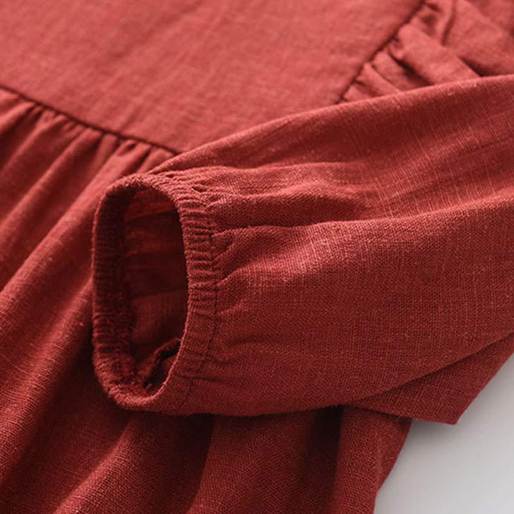 Generic Firebrick Ruffled Long Sleeve Romper Bodysuit, close-up of sleeve and ruffled detail in firebrick red fabric.
