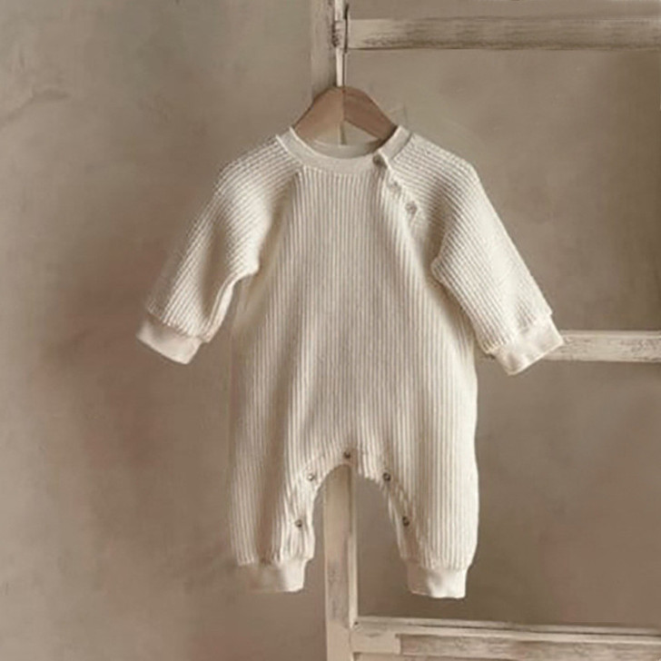 Generic Knitted Round Neck Bodysuit, cream-colored baby jumpsuit with long sleeves and button closures at the shoulders and crotch.