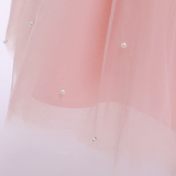 OONA Amelia Tulle Klosh, close-up image showcasing a soft pink tulle fabric adorned with small pearl embellishments.