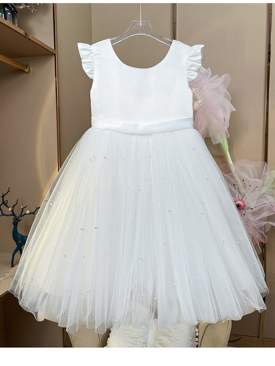 OONA Amelia Tulle Klosh, white formal dress with ruffled sleeve detail and pearl embellishments on a full tulle skirt for special occasions.
