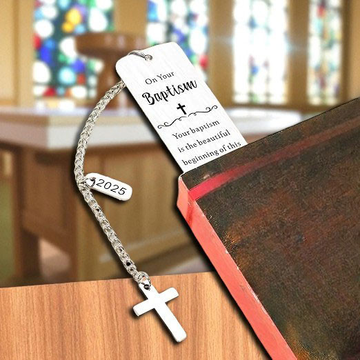 Minnie Me Silver Bookmark with Cross, an elegant religious bookmark featuring a cross design and a tag with the year 2025, placed on a wooden surface near a church altar or podium.