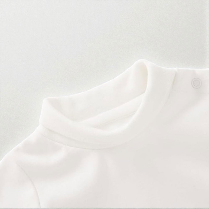 Minnie Me White Romper Cotton Essential, close-up of the soft white fabric and neckline of the baby romper with snap buttons on the shoulder.