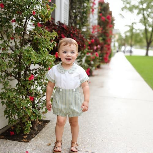 Minnie Me Elie Formal Set with short, a child's formal outfit featuring a white top and striped shorts, worn by a smiling toddler on a sidewalk with blooming bushes.