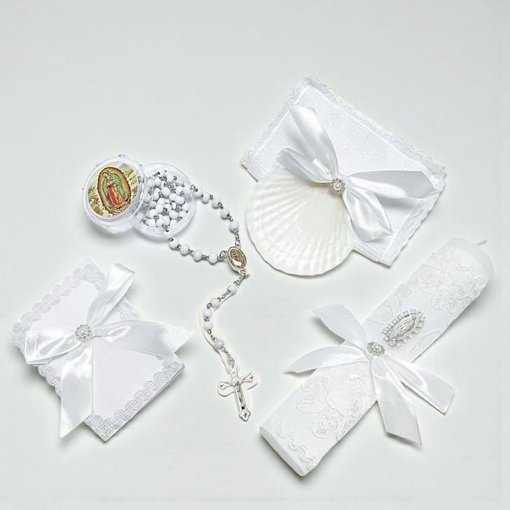Minnie Me White 5 PCS Baptism Kit, a collection of white baptism accessories including a rosary, lace-trimmed cloth, favor boxes with bows, and a shell-shaped holder for religious items.
