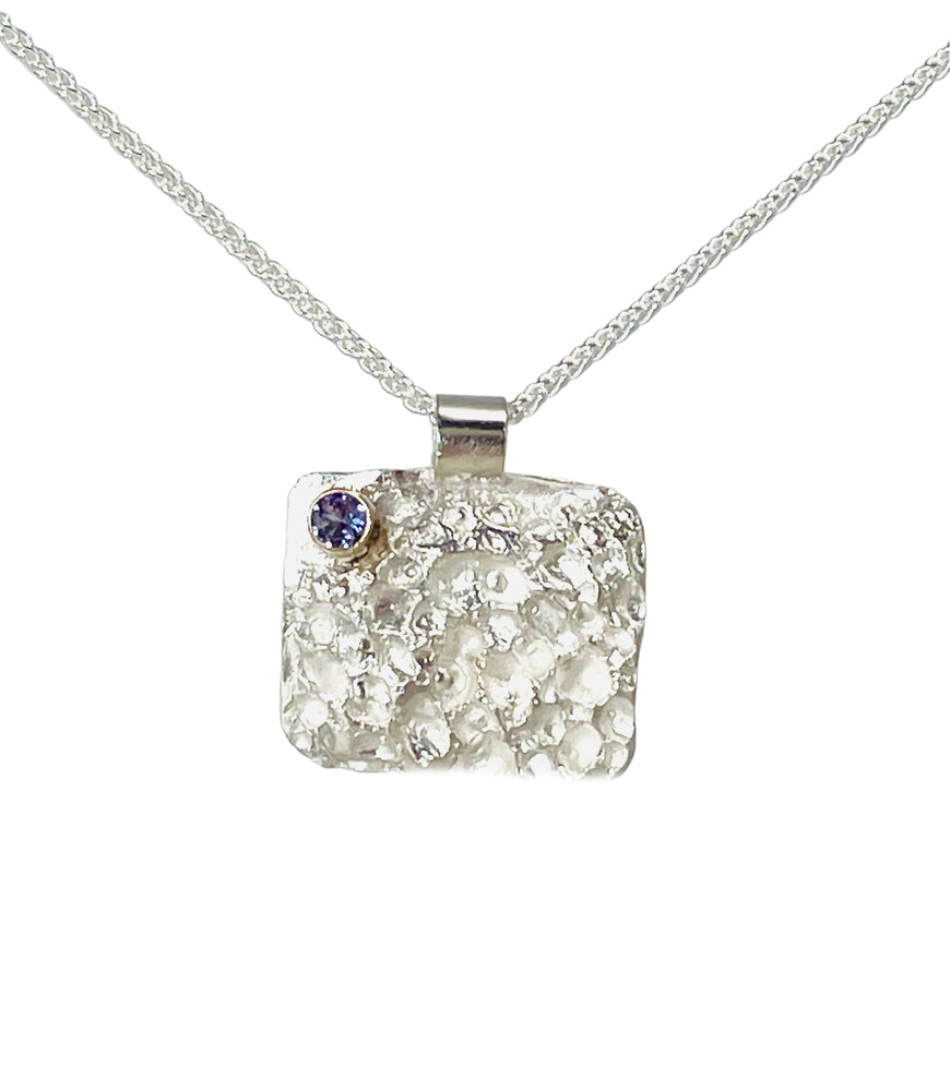 Textured sterling silver pendant with faceted tanzanite