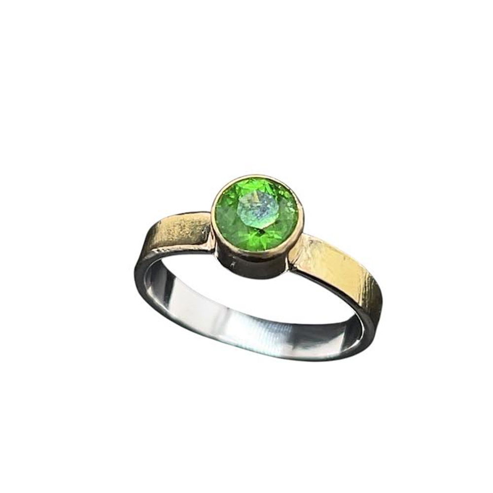 Tsavorite Garnet Ring in Gold & Silver. I faceted this deep emerald green garnet from Tanzania in one of my favorite designs called ‘Classic’ with 58 facets. These garnets are rare in sizes over a carat and this stone measures at 1.06 carats. The color is intense and vibrant and is set in 18K gold bezel with 14K Gold textured band over silver. The band texture has been lasered in with a custom pattern I designed and comes in a size 7.