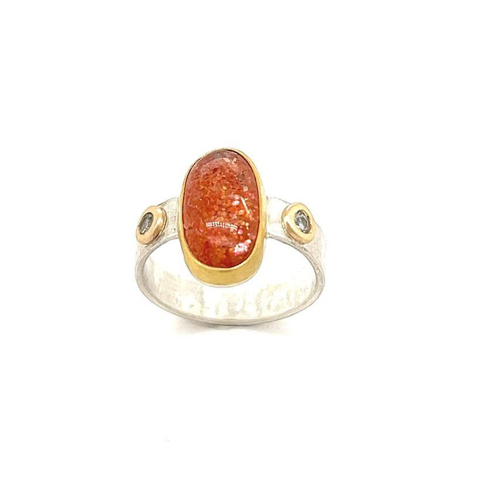 Eclipsite Ring in Gold and Silver. Highest quality Australian lattice sunstone which I cut into an elongated oval. Intense reflections from the inclusions that reflect all colors of the rainbow. Set in a 22K gold bezel with 14K gold and white sapphire accents. Sterling silver shank with textured metal in a size 6.5
