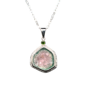 Watermelon Tourmaline Pendant.
I cut this perfectly shaped tourmaline crystal from Brazil in cross-section to highlight the color zoning within the crystal. Set in fine silver bezel with a green Chrome Dioptase accent stone and hand textured border.
18” chain included. 1”H x ¾ “ W