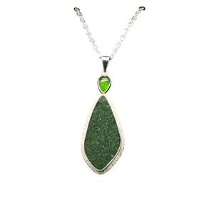 Druzy Uvarovite with Chrome Diopside Pendant.
This rare green stone comes from the Ural mountains in Russia and is a collection of green garnet crystals that are deposited on a fine matrix. The green garnets glisten like green sugar when the pendant is worn. I cut the freeform shape and matched it with a deep green chrome diopside accent stone that also comes from Russia. Set in fine silver with hand textured sterling silver and includes the 18” silver chain.