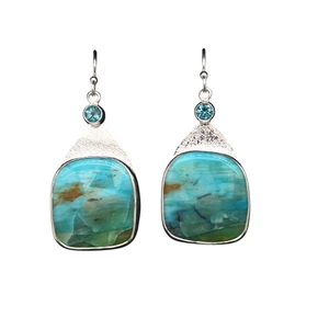 Petrified Wood Opal Earrings.
 This really cool material comes from Indonesia and I cut these unique shapes with a bookend cut technique so the earrings are mirror images of each other. Blue apatite accents with an ocean themed scene set in a fine silver bezel and sterling silver ear wire components. 1.25” L by 0.75”W.