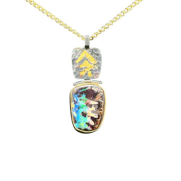 Australian Boulder Opal Pendant with 22K Gold. I cut this special boulder opal from a seam specimen from Australia. 22K high gold bezel with 22K gold Keumboo highlights with dark patina on textured silver sheet. The hinges allow for movement of the pendant and comes with an 18” 14K gold filled chain.
Opals naturally contain 4-10% water. It is NOT recommended to shower, wash, or expose opals to long periods of water contact.