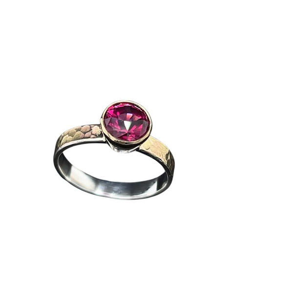 Rhodolite Garnet Ring with Gold. 
I custom cut this Intense Purplish pink rhodolite garnet from Congo, Africa. This area is well known for its unique garnet colors. The design is called ‘Clocktower’ and has a unique small square table which allows for more facets to be placed on the crown creating better scintillation and brightness. The stone is 1.8 carats and is set in 18K gold with a silver/14K gold shank with a custom texture that I created. Size 7.5 ring.
