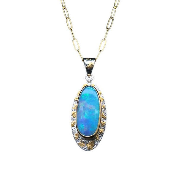 Welo Opal Pendant and 22k Gold. I cut this very bright and gemmy opal from a parcel of Ethiopian opal. Has multi-flashes of all the colors of the sky with blue, green, orange, red and yellow. This opal is exceptionally large and gemmy throughout. Set in a 22K gold bezel with 22K gold accents. Base layer is textured sterling silver and comes with an 18 inch 14K gold filled chain.
Opals naturally contain 4-10% water. It is NOT recommended to shower, wash, or expose opals to long periods of water contact.