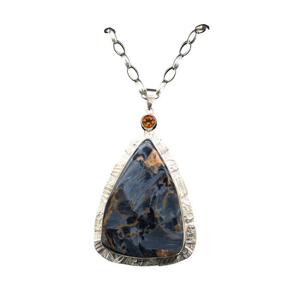 Pietersite Pendant & Citrine Accent. This rare gemstone is found in only one mine in Namibia Africa. It is a brecciated form of Tiger’s Eye. The stone displays optical sheen and movement when seen at different angles. I cut the stone to accentuate the unique sheen. A potpourri of silver textures and Brazilian citrine accent compliments the unique patterns in the stone. Set in fine silver and sterling silver with 18” chain included. 1 ½ “W by 2” L