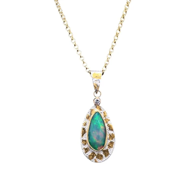 Opal Pendant with Diamond and 22K gold.
I cut this Ethiopian Welo Opal with facets to create a lot of scintillation in addition to the really bright green, red and blue flashes of color. Set in a solid 22K gold bezel on a silver backing with 22K gold Keumboo accents. A man made diamond accent really makes the pendant sparkle. Bail is custom made with 22K gold and silver and the 18” gold-filled chain is included. 1.25” L by 0.5”W.
Opals naturally contain 4-10% water. It is NOT recommended to shower, wash, or expose opals to long periods of water contact.