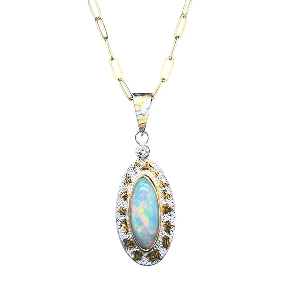Ethiopian Opal in 22K Gold with Diamond.
I cut this Marquis shaped Welo Opal and mounted it in a solid 22K gold bezel. Placed on a silver sheet with 22K gold Keumboo accents. The accent stone is a diamond, lab created and everything is set in 14K gold-filled components and an 18” gold filled chain is included. This opal is exceptionally bright and the colors are really vibrant. A top opal specimen from this area.
1 ¼”H by ½”W
Opals naturally contain 4-10% water. It is NOT recommended to shower, wash, or expose opals to long periods of water contact.