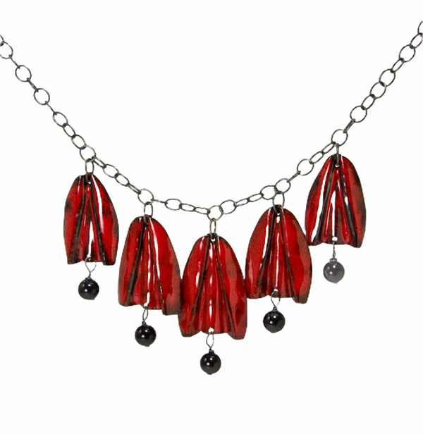 Red and gold enamel tulip flowers with black onyx drops hang from an oxidized sterling silver chain