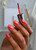 Hand holding nail brush with The GelBottle Inc BIAB™ builder gel on the nails in the shade, Passionate.
