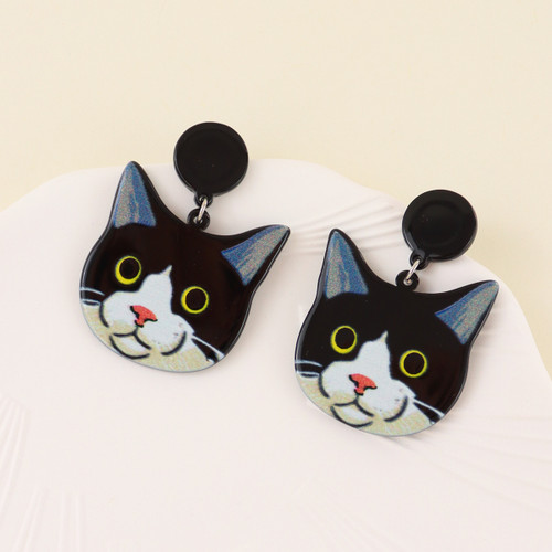 Black and white cat face earrings hung from round black coloured stud