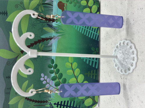 Purple dangly earrings with engraved frangipani design