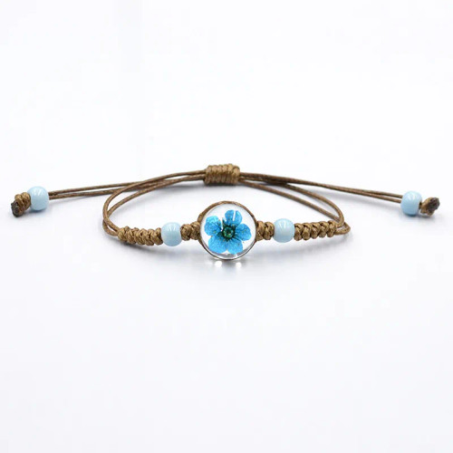 Bracelet with turquoise dried flower in a glass ball on brown cord