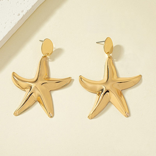 Large gold coloured starfish earrings dangling from round studs