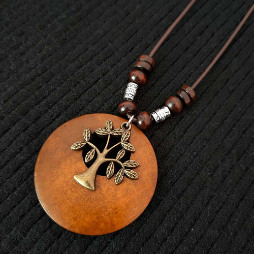 Wooden pendant with antique look tree emblem on brown cord