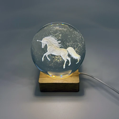 Unicorn etched into glass crystal ball on wooden LED lamp