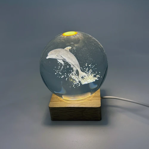 Dolphin in crystal ball with LED light on wood base