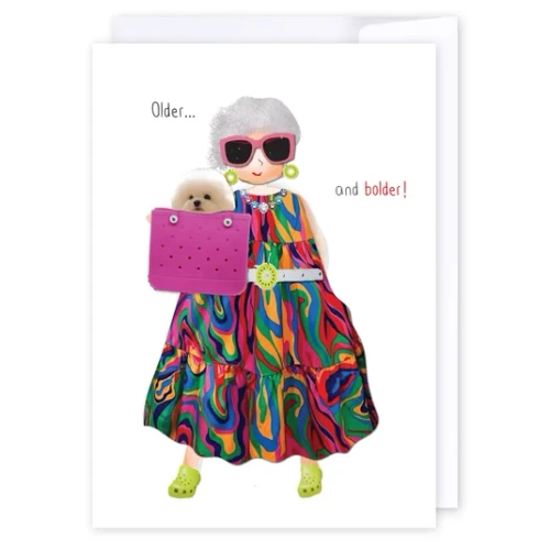 Older and Bolder birthday card with colourful dressed-up woman in pink sunglasses and a small dog in her handbag