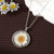 Dried pressed flower in resin pendant necklace with silver coloured surround on chain