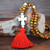 Long wood bead boho style pendant necklace with red tassel and white cross shape