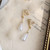 Drop white pearl and gold clip on earrings