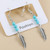 silver coloured feather with turquoise coloured bead earrings on hook