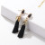 Black Tassel earring with gold coloured crown hanging from black coloured stone stud