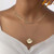 Gold coloured layered chain necklace with clam and faux pearl pendant